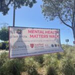 Mental Health Matters Walk Banner hanging between trees.